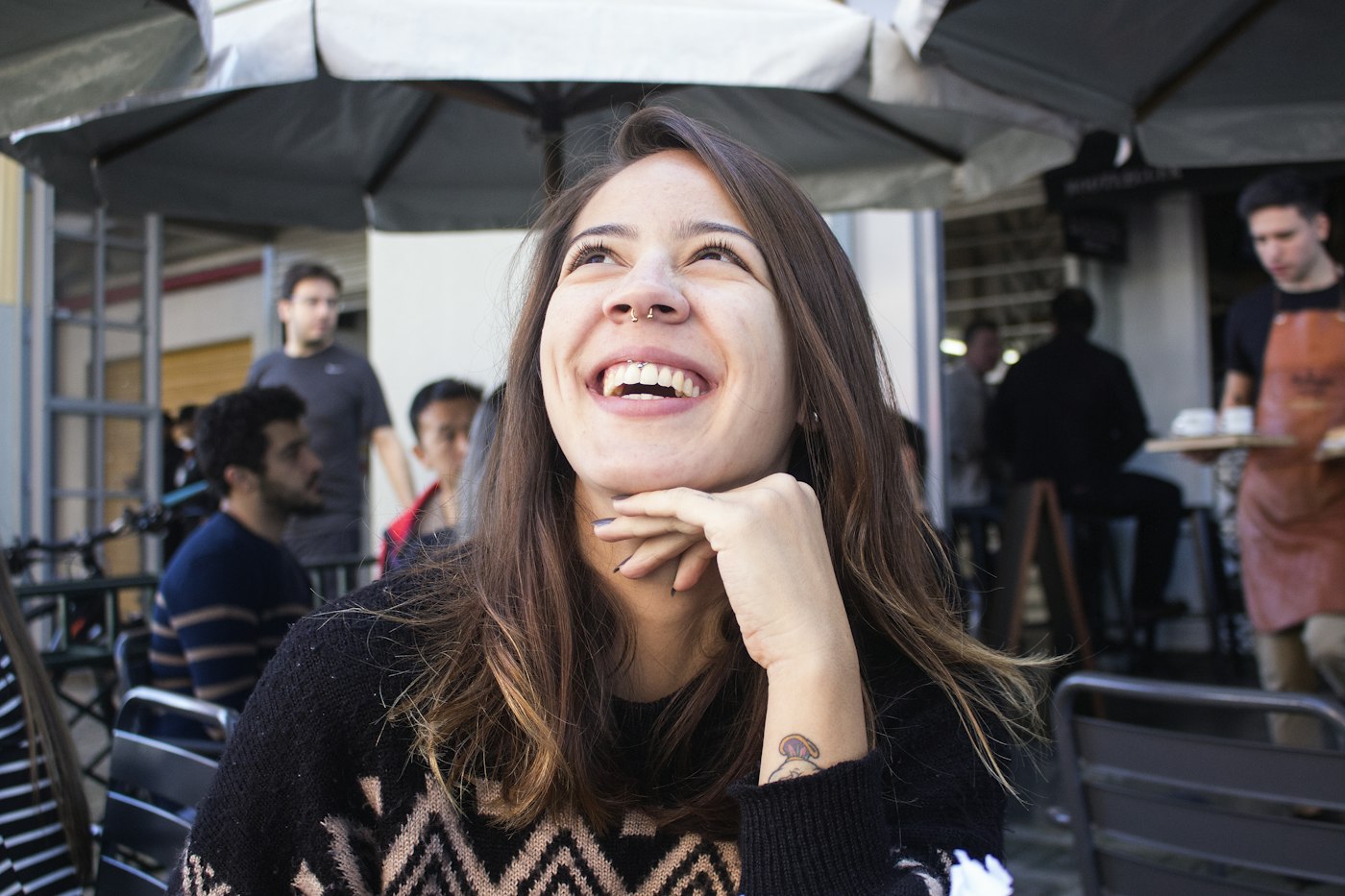 A woman laughing at an outdoor café